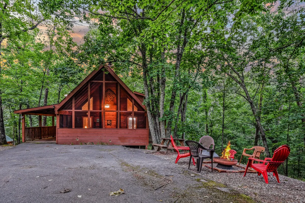 A cozy outdoor fire pit area with comfortable seating, encircled by trees and located near the cabin. The setting is ideal for gathering, stargazing, and enjoying fireside treats.
