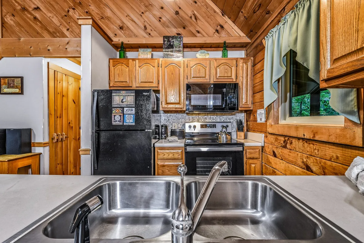 An inviting kitchen scene featuring a central island, wooden cabinetry, modern appliances, and ample space—perfect for cooking, entertaining, and sharing meals. The layout is open and bright, ideal for group gatherings and communal experiences.