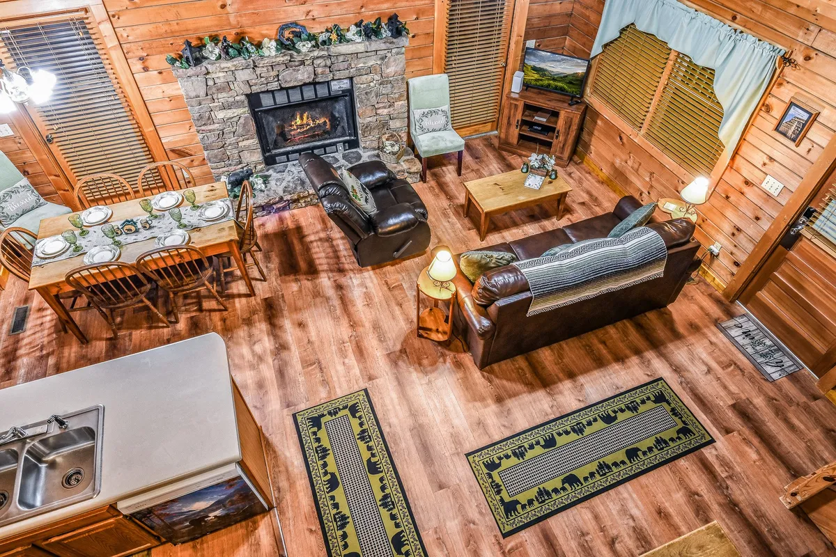 A warm, inviting interior with a stone fireplace as the focal point, flanked by leather sofas and a dining table. The ambiance is perfect for cozy evenings, intimate conversations, or sharing a glass of wine after exploring the local area.